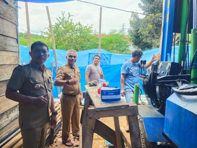 
 Kepala Desa Banggai, La Ode Upa (kiri) bersama Camat Duruka Herman (kedua dari kiri) di lokasi pembangunan sumur bor. Foto: Istimewa