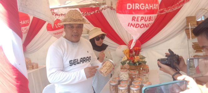 
 Bupati Konawe Utara, Ruksamin saat mengunjungi salah satu stand UMKM di Pantai Taipa. Foto: Istimewa