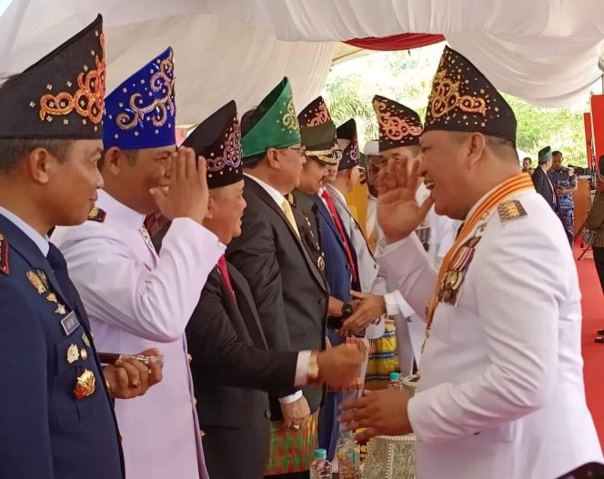 
 Bupati Konawe Utara, Ruksamin menyalami para pejabat yang hadir pada upacara peringatan HUT Konut ke-17. Foto: Istimewa