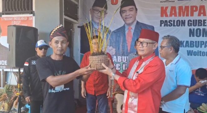 
 Petani memberikan dua tanaman Anggrek Sorume kepada Lukman Abunawas. Foto: Penafaktual.com