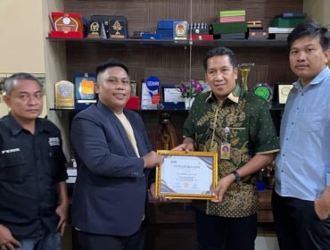 Ketua Pengda JMSI Sultra, Adhi Yaksa Pratama menyerahkan penghargaan JMSI Sultra Award kepada Plt Rektor Universitas Halu Oleo (UHO), Dr. Herman, S.H., LL.M. Foto: Istimewa