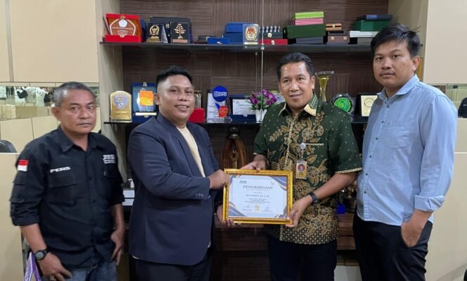 
 Ketua Pengda JMSI Sultra, Adhi Yaksa Pratama menyerahkan penghargaan JMSI Sultra Award kepada Plt Rektor Universitas Halu Oleo (UHO), Dr. Herman, S.H., LL.M. Foto: Istimewa