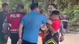 Lurah Watulondo, Mohammad Rusdi Rudi (pertama dari kanan) saat disikut oleh pria yang mengaku ormas dalam aksi pemblokiran jalan. Foto: Istimewa.