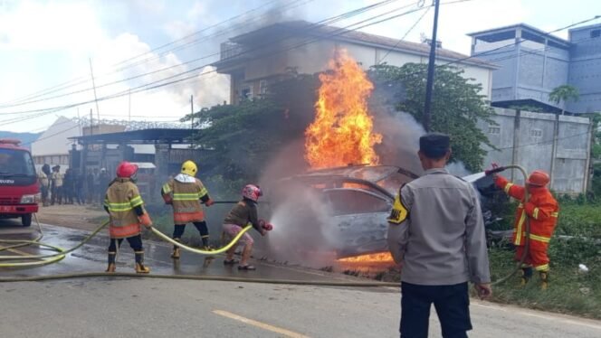 
 Petugas Damkar Kabupaten Bombana tengah memadamkan api yang membakar mobil Daihatsu Sigra. Foto: Istimewa