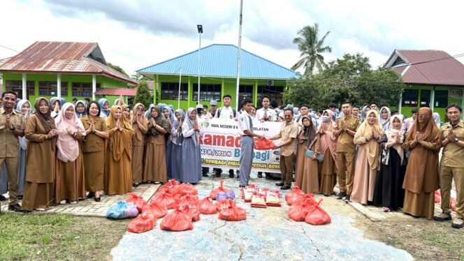 
 Kepala SMAN 8 Konsel, La Ode Sanando, S.Si.,M.Si., menyerahkan bantuan paket sembako kepada siswa. Foto: Istimewa