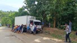 Sejumlah warga saat mengevakuasi mobil box yang terbalik di Jalan Trans Sulawesi Konut. Foto: Istimewa