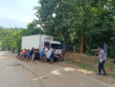 Sejumlah warga saat mengevakuasi mobil box yang terbalik di Jalan Trans Sulawesi Konut. Foto: Istimewa