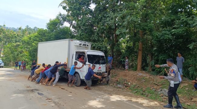 Sejumlah warga saat mengevakuasi mobil box yang terbalik di Jalan Trans Sulawesi Konut. Foto: Istimewa