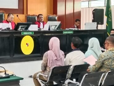 Eks Pj. Bupati Muna Barat Bahri (kanan) tampak memegang map saat menjalani pemeriksaan di ruang sidang Kusumah Atmadja PN Kendari. Foto: penafaktual.com