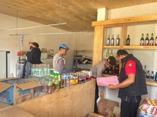 Personel Satgas Gakkum Operasi Pekat Anoa 2026 Polres Konawe Utara mengamankan 12 botol miras yang disita dari Toko Sahirman di Andowia. Foto: Istimewa  
