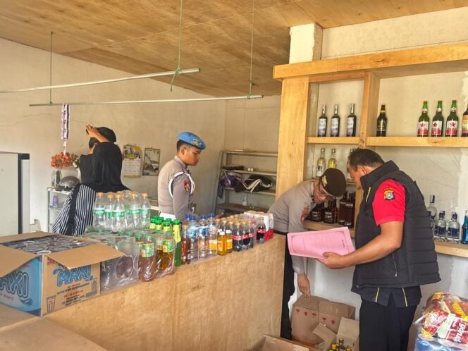 
 Personel Satgas Gakkum Operasi Pekat Anoa 2026 Polres Konawe Utara mengamankan 12 botol miras yang disita dari Toko Sahirman di Andowia. Foto: Istimewa  