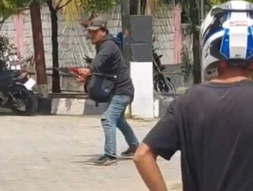 Tampak seorang pria berjaket hitam memegang senjata tajam jenis parang mengamuk di SPBU Wulele Kendari. Foto: Istimewa.
