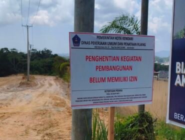 Plang penghentian aktivitas pembangunan perumahan yang dipasang Pemkot Kendari di lahan bersengketa di Puuwatu Kendari. Foto: Istimewa