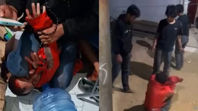 
 Seorang pria yang mengenakan sweater merah babak belur diamuk massa setelah kedapatan masuk rumah warga dan hendak merampok di Kendari. Foto: Istimewa