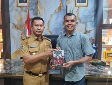 Rasmin Jaya menyerahkan hasil karyanya kepada Bupati Muna Barat, La Ode Darwin. Foto: Istimewa