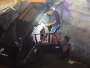 Tampak sebuah mobil berwarna hitam terperosok ke dalam lubang drainase proyek pembangunan deker di Kolaka. Foto: Istimewa