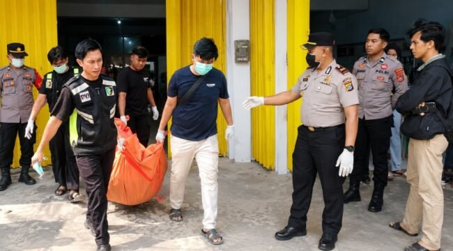 Petugas kepolisian saat mengevakuasi jenazah korban yang ditemukan tewas membusuk di Kendari. Foto: Istimewa
