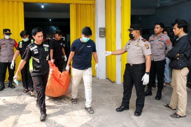 
 Petugas kepolisian saat mengevakuasi jenazah korban yang ditemukan tewas membusuk di Kendari. Foto: Istimewa