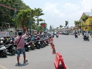 Tampak salah seorang juru parkir di kawasan Eks MTQ Kendari saat mengarahkan pengendara yang melintas untuk memarkirkan kendaraannya. Foto: Penafaktual.com
