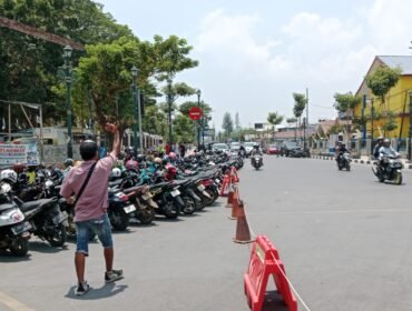Tampak salah seorang juru parkir di kawasan Eks MTQ Kendari saat mengarahkan pengendara yang melintas untuk memarkirkan kendaraannya. Foto: Penafaktual.com