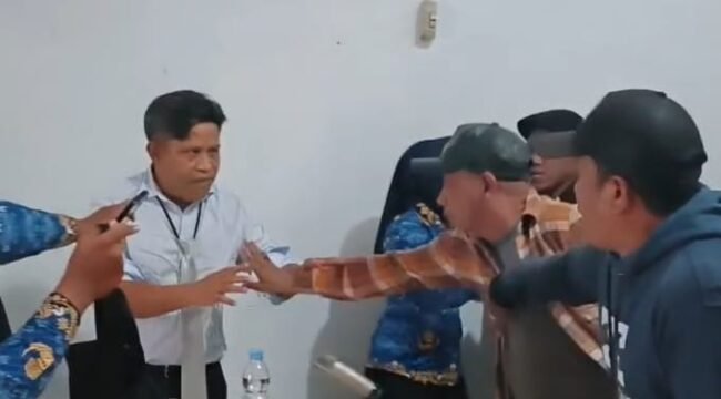 Kadis Pariwisata Sultra, Ridwan Badallah (kiri) tampak hendak ditarik oleh massa saat didatangi di kantornya. Foto: Istimewa